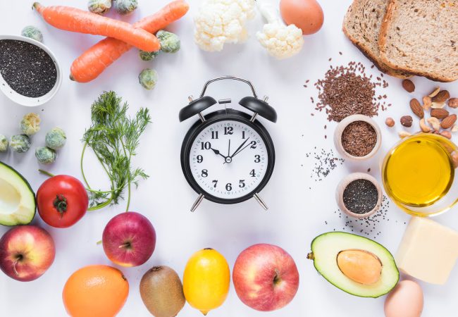 variety-ingredients-with-alarm-clock-arranged-against-isolated-white-background_23-2148026949